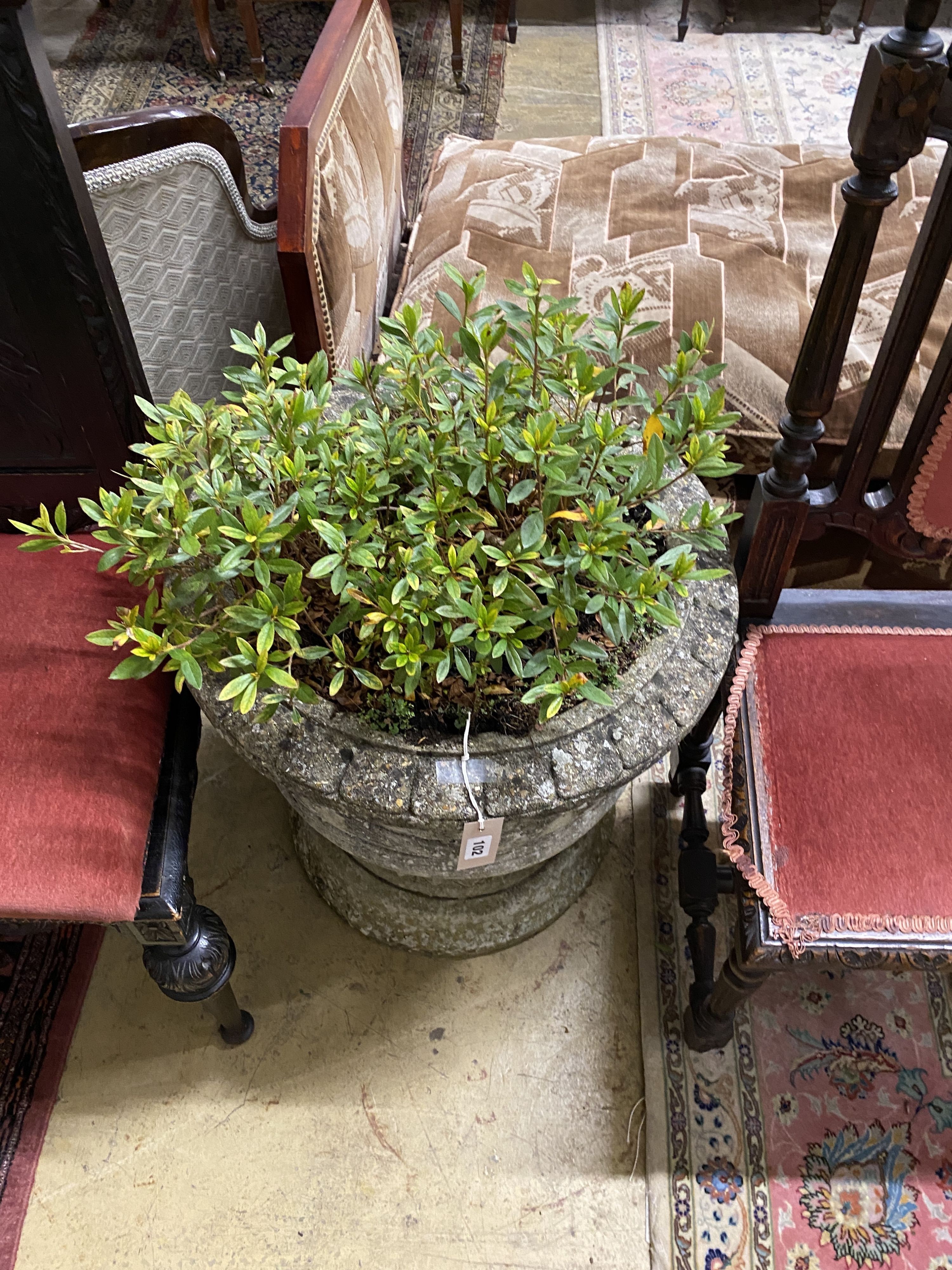 A circular reconstituted stone garden planter with ribbon fold moulded body, diameter 58cm, height 59cm